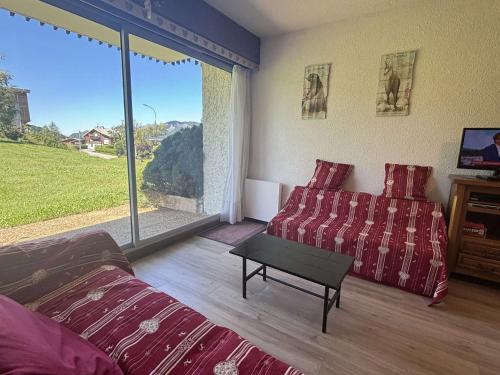 - une chambre avec un lit, un canapé et une grande fenêtre dans l'établissement Studio au pied des pistes à Notre-Dame-de-Bellecombe, 4 pers, tennis et piscine l'été - FR-1-595-94, à Notre-Dame-de-Bellecombe