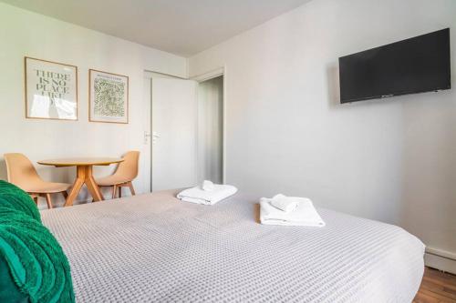 une chambre avec un lit et une table avec des chaises dans l'établissement Studio Cosy Proche Paris - Montreuil, à Montreuil