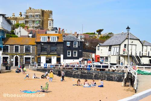 a group of people on a beach near a harbor at Family Seaside Bungalow - Max 6 Adults Only in Margate