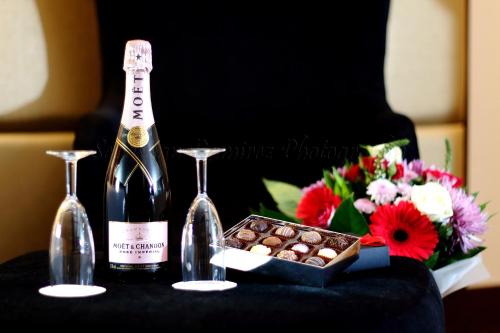 a bottle of champagne and a box of chocolates and flowers at Montcalm Piccadilly Townhouse, London West End in London