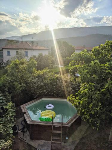 une petite piscine d'eau avec un arc-en-ciel en arrière-plan dans l'établissement El Solà - Appartement avec accès piscine et jardin, à Corneilla-de-Conflent