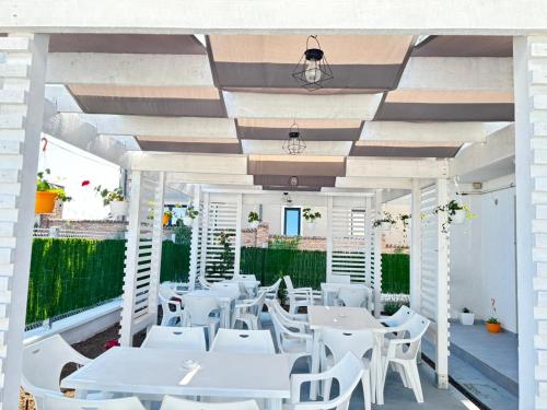 a restaurant with white tables and white chairs at Waterman in Costinesti