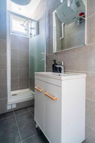 une salle de bain avec un lavabo et une douche dans l'établissement Agréable studio dans la paisbile Ville Montreuil, à Montreuil