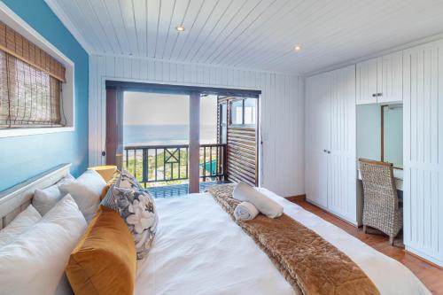 a bedroom with a large bed with a view of the ocean at Peak's Cabin - Endless Ocean Views - Fireplace - Fast WiFi in Wilderness
