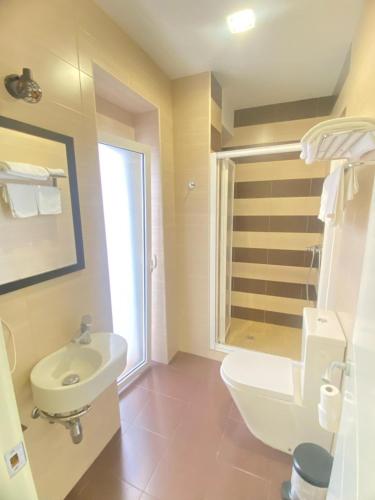 a bathroom with a white toilet and a sink at Hostal Fabiola in Seville