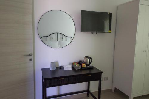 a mirror hanging on a wall with a table with a mirror at Villa la sorgente in Guardia Vomano
