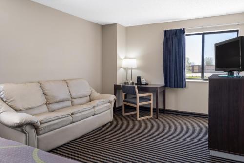 a living room with a couch and a desk and a television at Super 8 by Wyndham Humboldt in Humboldt