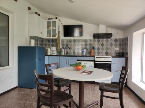 eine Küche mit einem Tisch und Stühlen sowie einem blauen Kühlschrank in der Unterkunft Vintage House Prima Priori in Vaklino