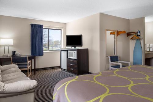a hotel room with a bed and a flat screen tv at Super 8 by Wyndham Humboldt in Humboldt