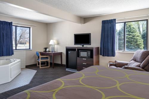 a hotel room with a bed and a flat screen tv at Super 8 by Wyndham Humboldt in Humboldt