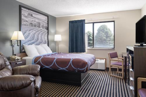 a hotel room with a bed and a window at Super 8 by Wyndham Humboldt in Humboldt