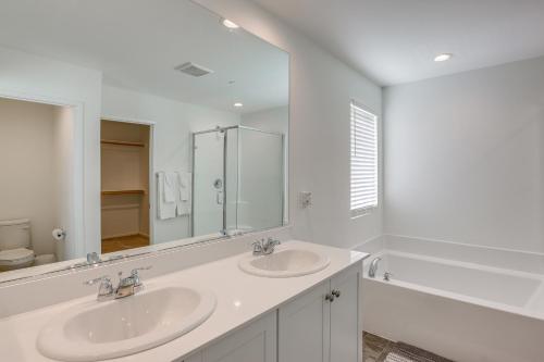 a white bathroom with two sinks and a mirror at Coachella Home with Game Room and 1 PM Check-Out in Coachella