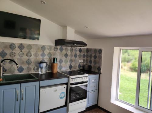 eine Küche mit einem Herd, einem Waschbecken und einem Fenster in der Unterkunft Vintage House Prima Priori in Vaklino