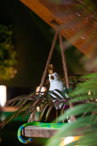 a bird is sitting on a toy swing at Dynasty Jungle Home Spa Jacuzzi in Holtzheim