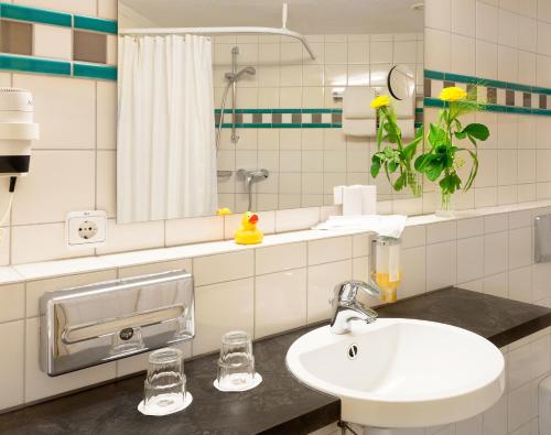 a bathroom with a sink and a mirror at The Domicil Hotel Frankfurt City in Frankfurt/Main