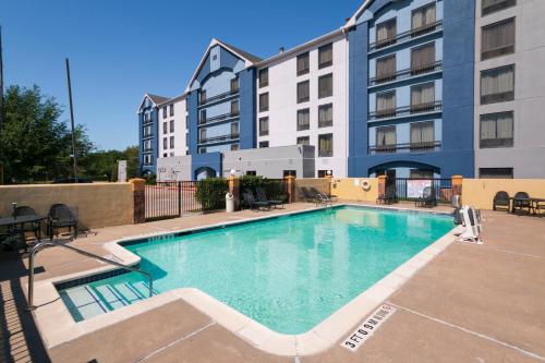 a large swimming pool in front of a building at Sonesta Essential NW Houston in Houston
