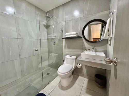 ein Badezimmer mit Toilette, Waschbecken und Spiegel in der Unterkunft Habitación hotelera 5min de la playa by G P S rentas in Mazatlán