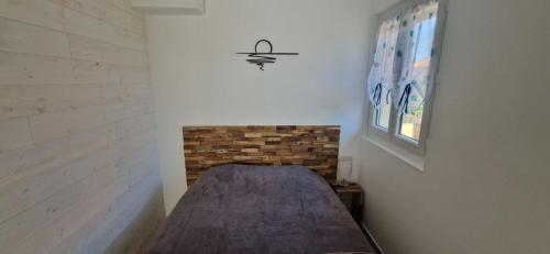 un lit dans une chambre avec un mur de briques dans l'établissement Résidence Vera Cruz à 50m de la plage, à Canet