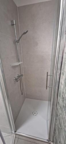 une douche avec une porte vitrée dans une salle de bain dans l'établissement Résidence Vera Cruz à 50m de la plage, à Canet