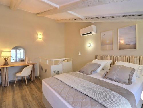 a bedroom with a large bed and a desk at La Bohème Mouriès in Mouriès
