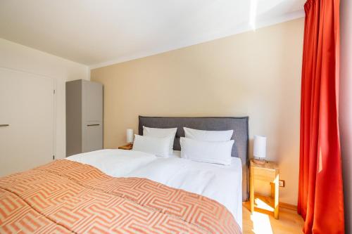 een slaapkamer met een groot bed en een rood gordijn bij Eagle mit Ostseeblick - Haus Fore zu Schloss Ranzow in Lohme