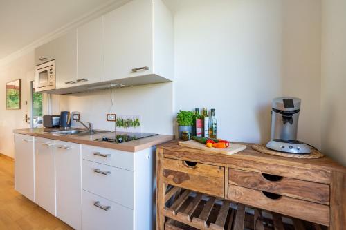een keuken met witte kasten en een houten aanrechtblad bij Eagle mit Ostseeblick - Haus Fore zu Schloss Ranzow in Lohme