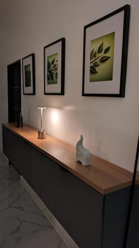 a desk with a lamp on a wall with pictures at Eco luxury apartments- Lekki Phase 1 in Lekki