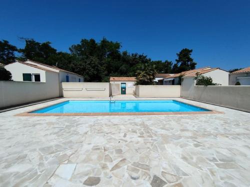 une piscine dans l'arrière-cour d'une maison dans l'établissement Maisonnette à Chaucre en résidence avec piscine collective, à Saint-Georges-dʼOléron
