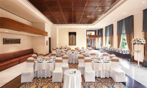 a banquet hall with white tables and white chairs at Taj Krishna in Hyderabad