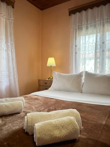 a bedroom with a large bed with white pillows and a window at Rustic House in Miléa