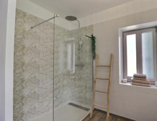 a shower with a glass door in a bathroom at La Bohème Mouriès in Mouriès