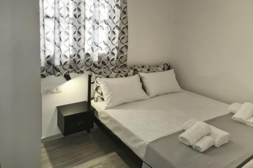 a bedroom with a bed with white sheets and a window at Mary's House 1 in Skiros
