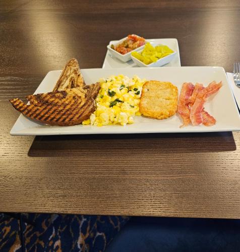 a plate of breakfast food with eggs bacon and toast at Hotel Westport Kansas City, Tapestry Collection by Hilton in Kansas City