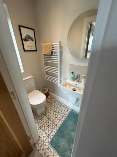 a bathroom with a toilet and a sink and a mirror at Mary’s Seaview Clifden in Galway