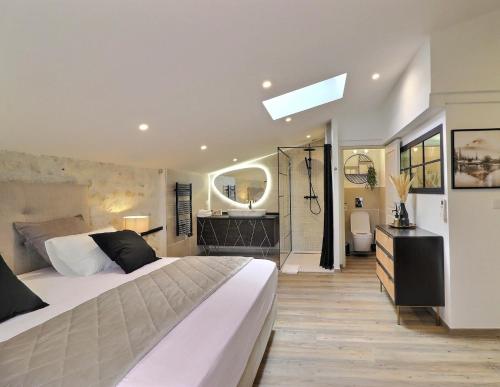 a bedroom with a large bed and a bathroom at La Bohème Mouriès in Mouriès