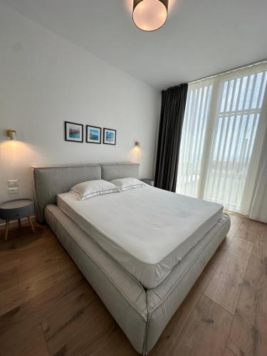 a large bed in a bedroom with a large window at Dua Green Coast in Palasë