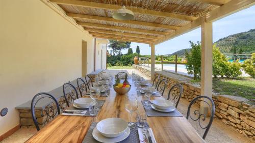 a long wooden table with chairs and plates and wine glasses at Nerino in Calci
