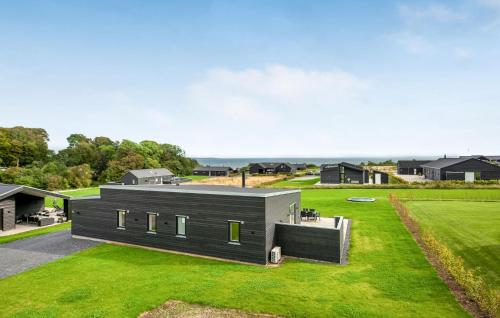 a black house with a large yard with grass at Three-Bedroom Holiday Home In Haderslev in Haderslev