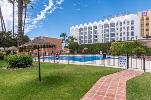 a resort with a swimming pool and a hotel at Renovated apartment on beachside with pool in Nerja