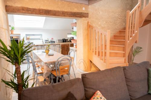 un salon avec un canapé et une table et une cuisine dans l'établissement Les gîtes des Châteaux - Les Brûleries, à Vallières-les-Grandes