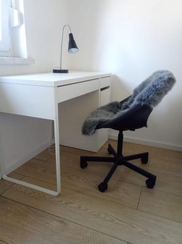 a desk with a chair and a desk with a lamp at Lovely flat, city center with free parking in Varaždin