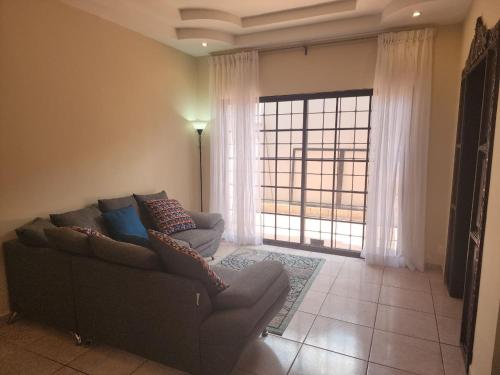 a living room with a couch and a large window at Twin House in San Pedro Sula