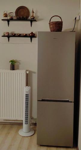 a refrigerator in a room with a radiator and a fan at Allin home in Mantoúkion