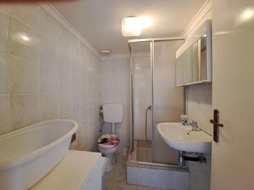 a bathroom with a tub and a sink and a toilet at Ithaka 1 in Kástro Tornéze