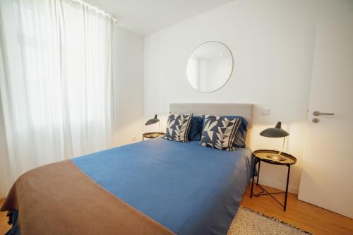 a bedroom with a blue bed and a mirror at Douro Panoramic Views by Vacationy in Bandeira