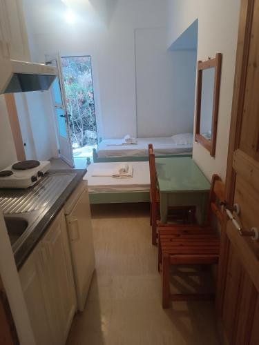 a kitchen with a table and a room with a bed at NIKOS APARTMENTS and PENTHOUSE in Vasiliki