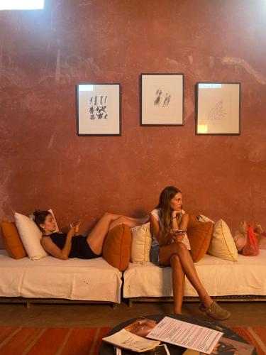 two women sitting on a couch with drinks at La Ferme Berbere Adult only in El Harkat