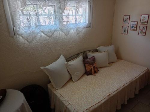 a bedroom with a bed with white pillows and a window at Paradise in Loutrá Elevtherón