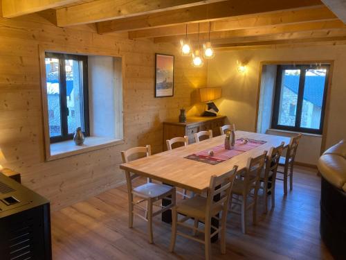 une salle à manger avec une table et des chaises en bois dans l'établissement Maison Canelle Le Clos des Ours, à Matemale