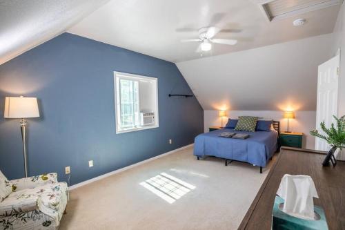 a blue bedroom with a bed and a couch at Spacious Family Home with Hot Tub in Ellensburg